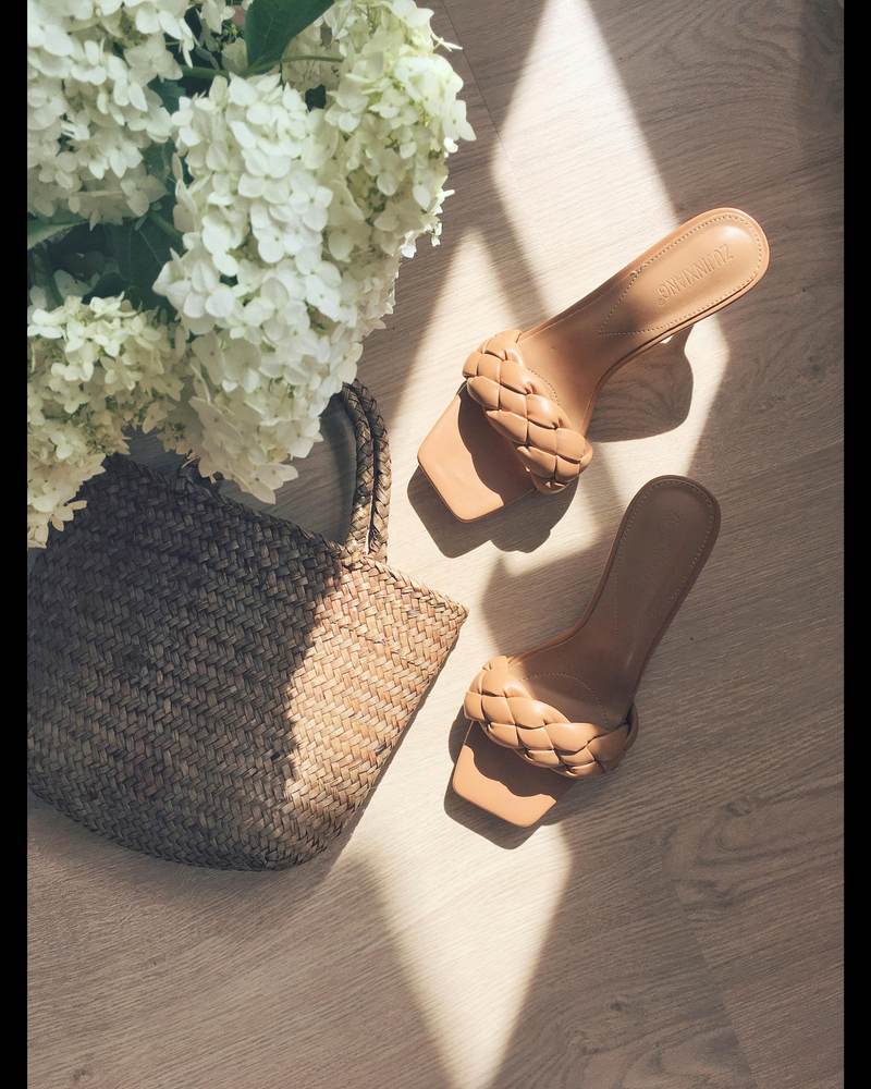 Tan braided sandals flatlay with woven basket bag